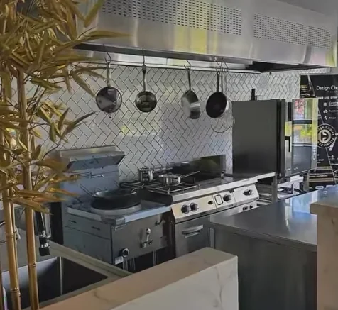 Commercial kitchen display with wok burners, range, combi oven and stainless steel benches in the Petra Group Lansvale showroom